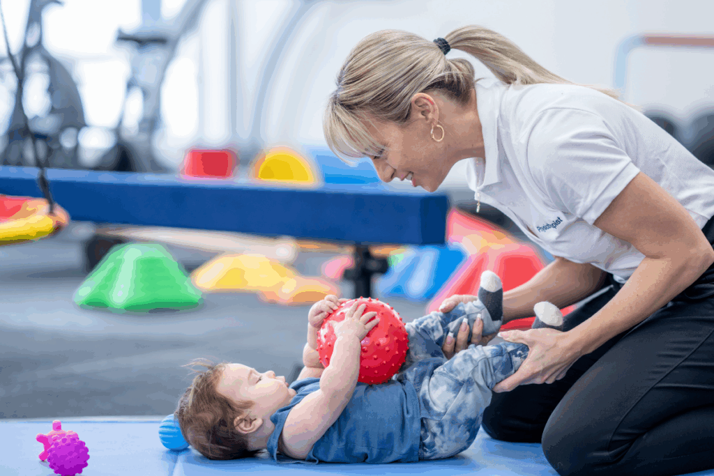 Early Intervention Therapy with a baby holding a ball