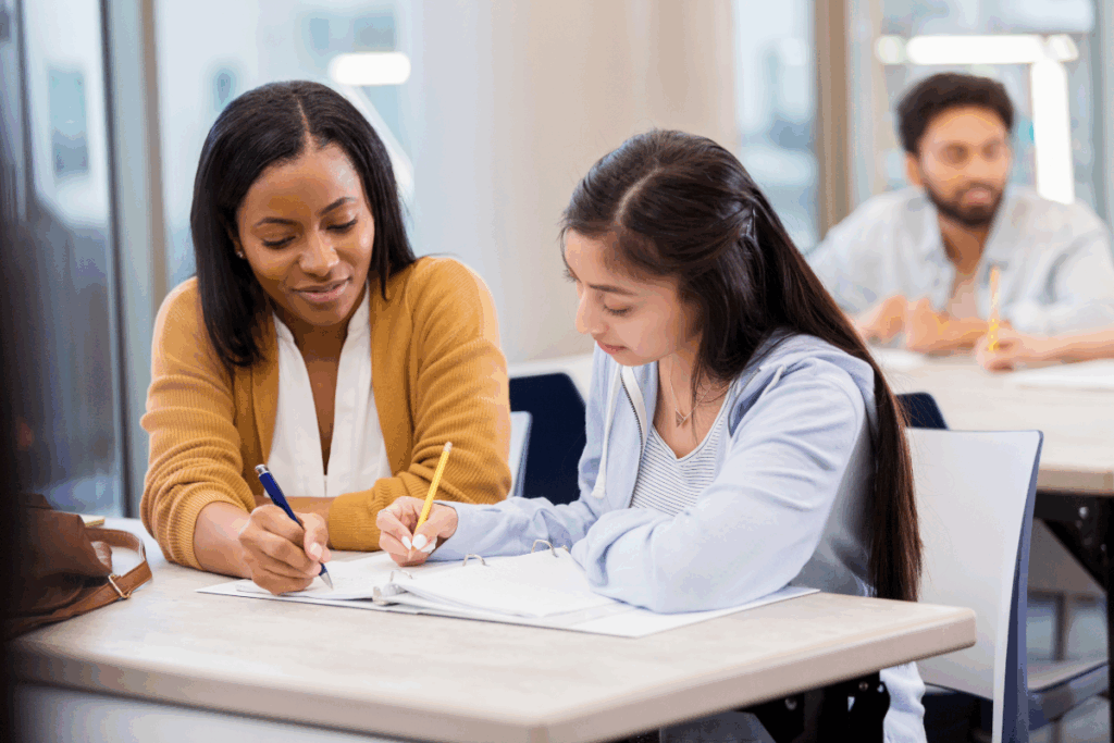 Student with a disability getting help from a classroom attendant or support professional
