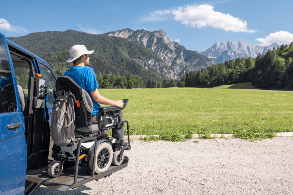 Man in a wheelchair accessible van looking out over mountains