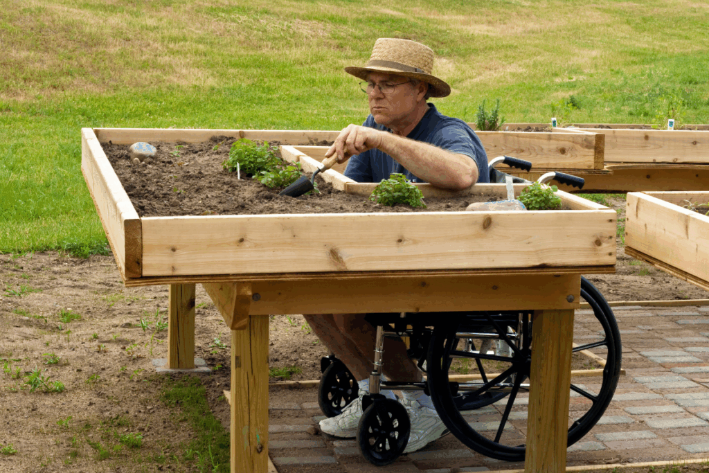 a man in a wheelchair tending to a garden