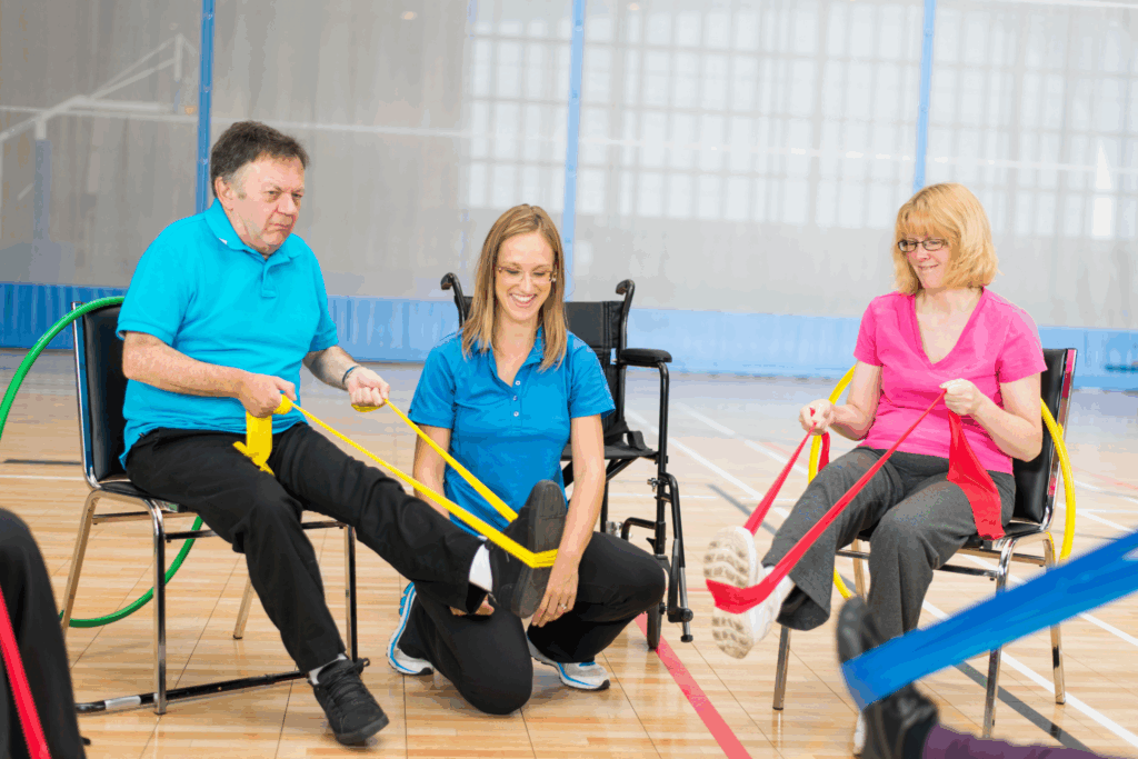 two adults with stretch bands and one physical therapist overseeing excercises
