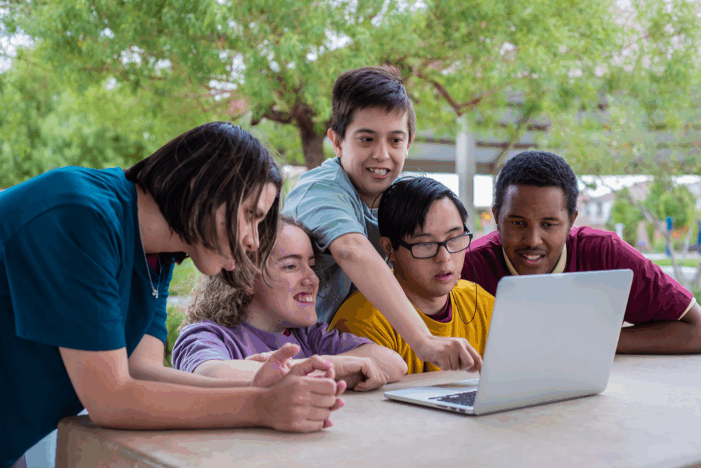A group of kids with disabilities looking at a laptop