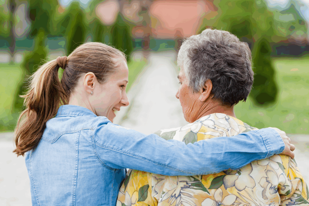 elderly woman facing away with a younger woman comforting her