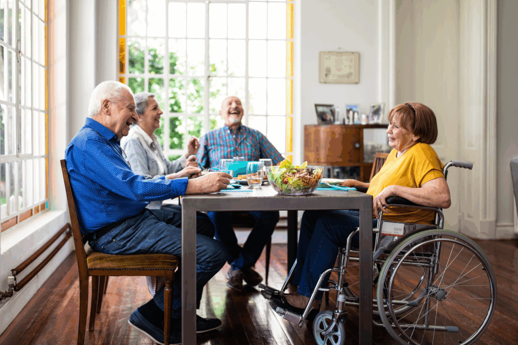 A group of elderly people sitting around a table one is in a wheelchair