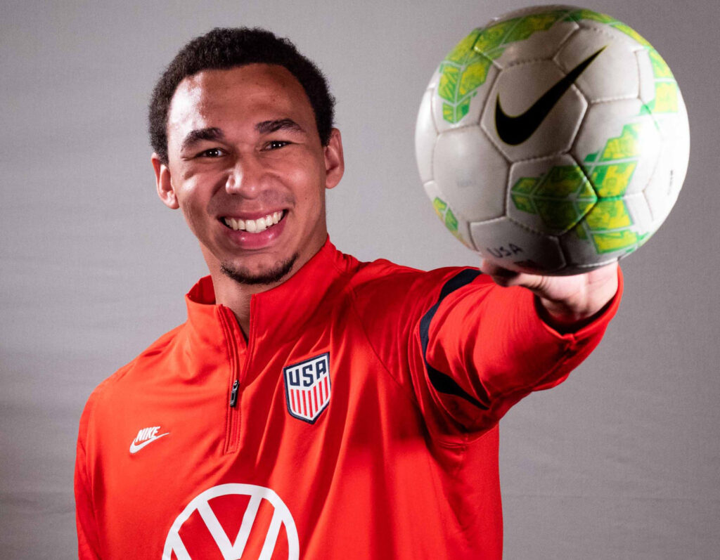 Matt Downing wearing a US Soccer jersey and palming a soccer ball