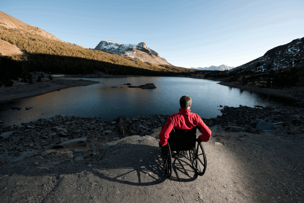 A man in a wheelchair looking over a lake