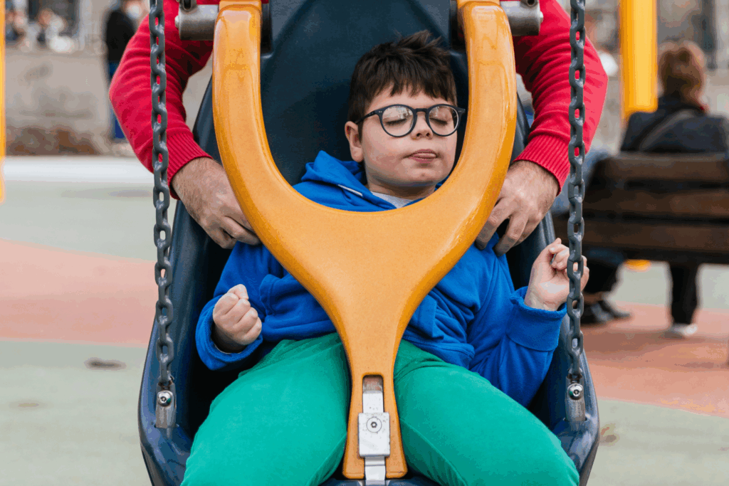 an older child in a park swing designed for people with disabilities