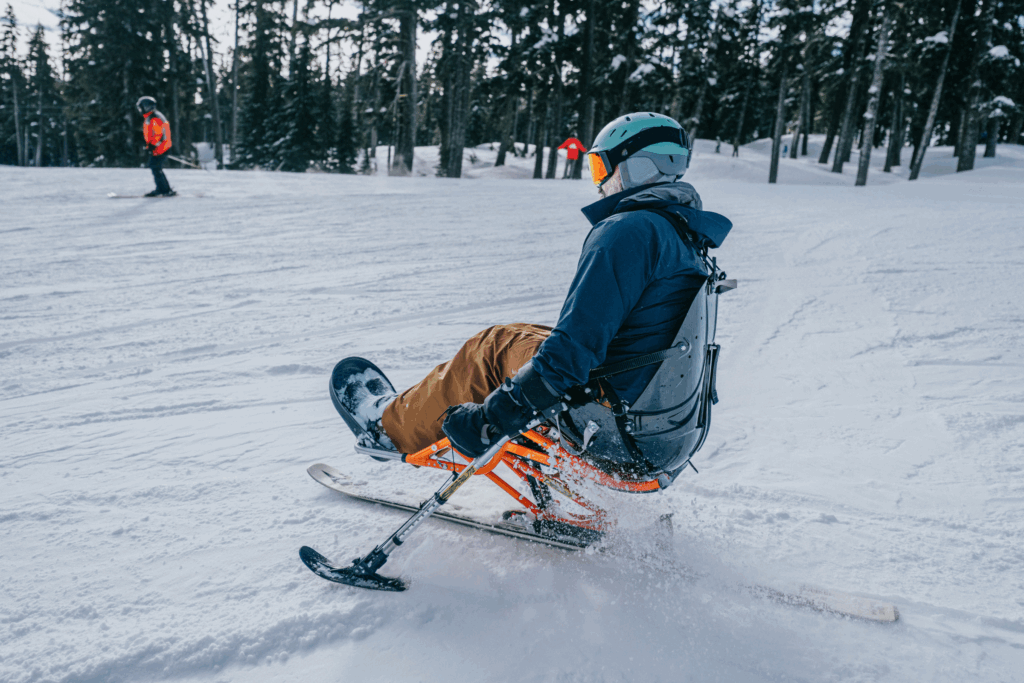 A man in using adaptive ski equipment