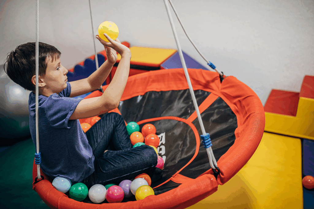 kid in a floating trampoline playing with balls as a sensory activity