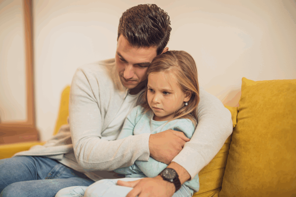 child who is overwhelmed gets a hug from a parent to calm them down