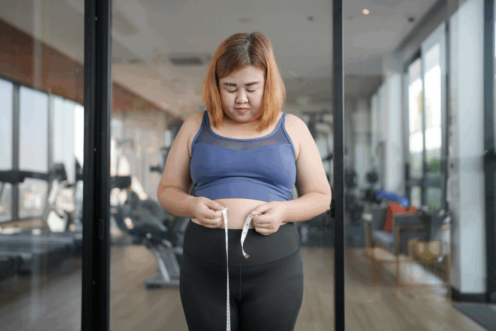Girl with tape measure measuring her waist