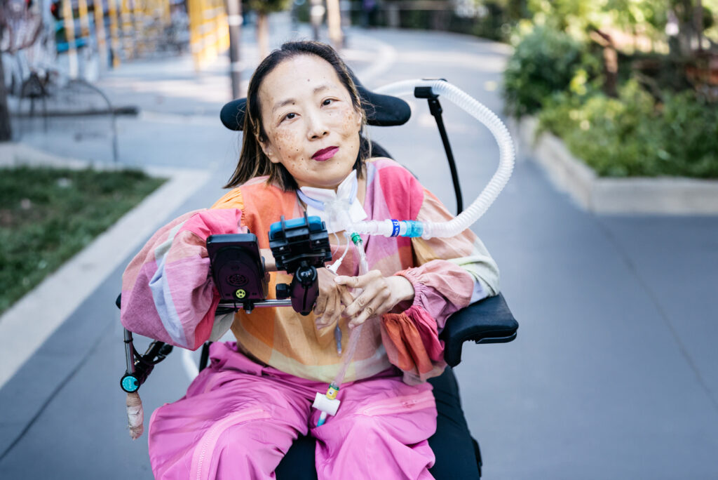 Alice Wong, disability activist seated in her wheelchair