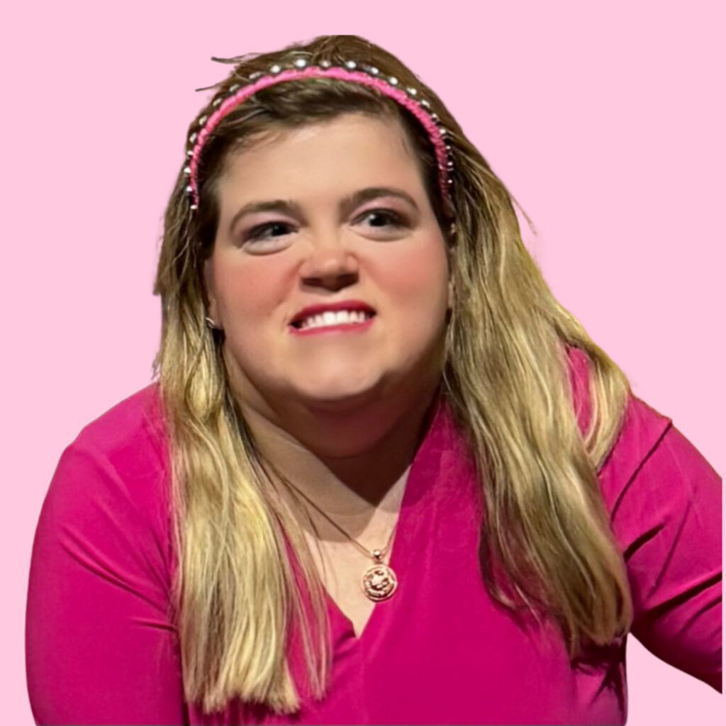 photo of a woman with blonde hair in pink shirt on a pink background. She is smiling