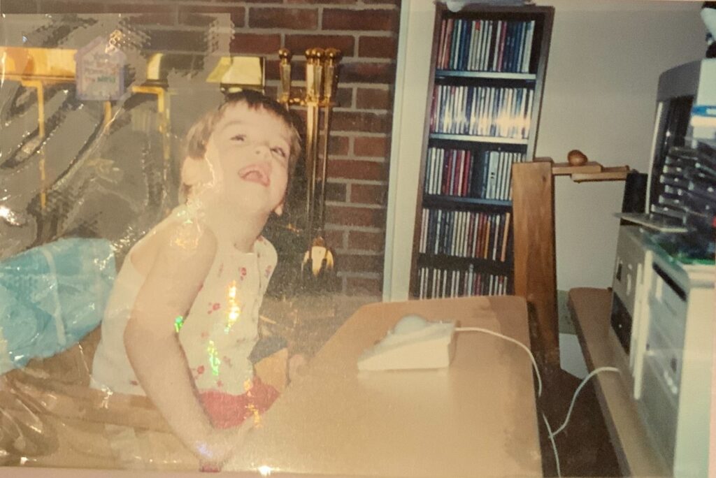 a young girl sits at a computer