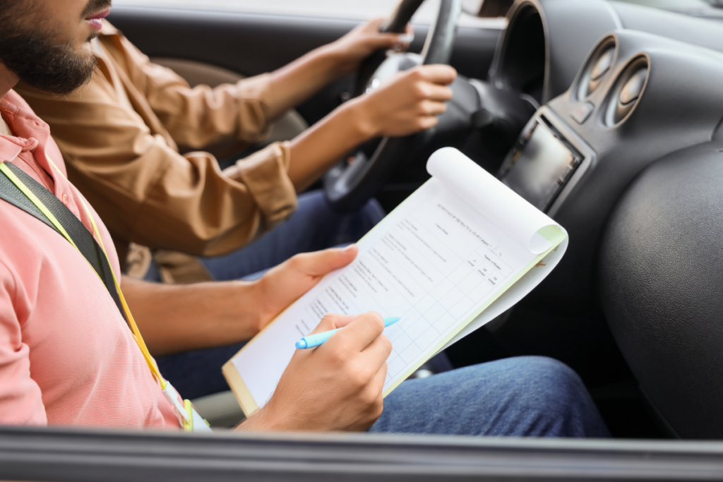two people in a car, one is driving and the other is holding a clipboard and taking notes